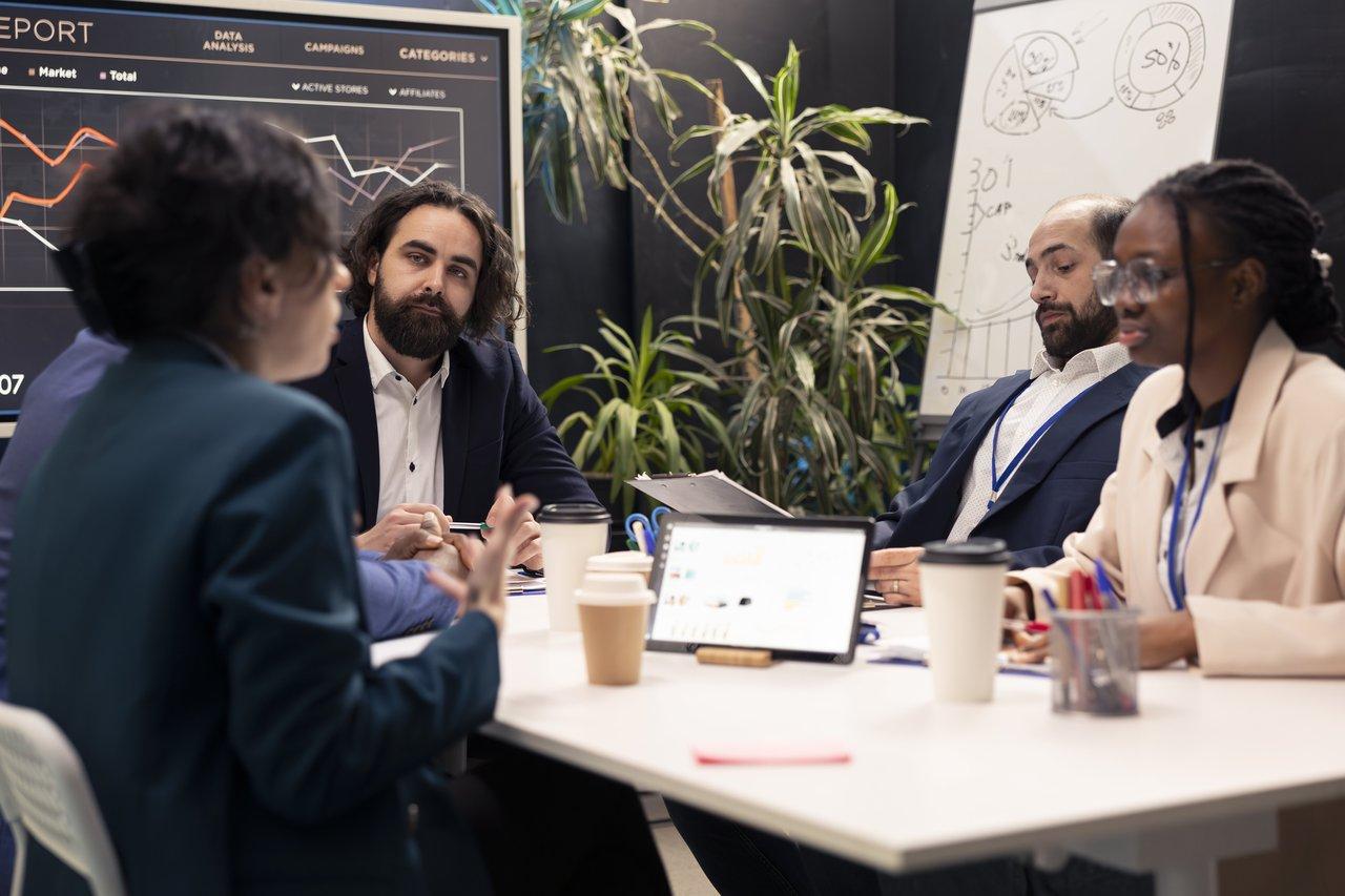 Une réunion d'équipe dédiée à la digital transformation meeting, analysant des indicateurs de performance sur un tableau interactif.